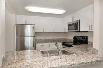 A kitchen with granite countertops and stainless steel appliances.